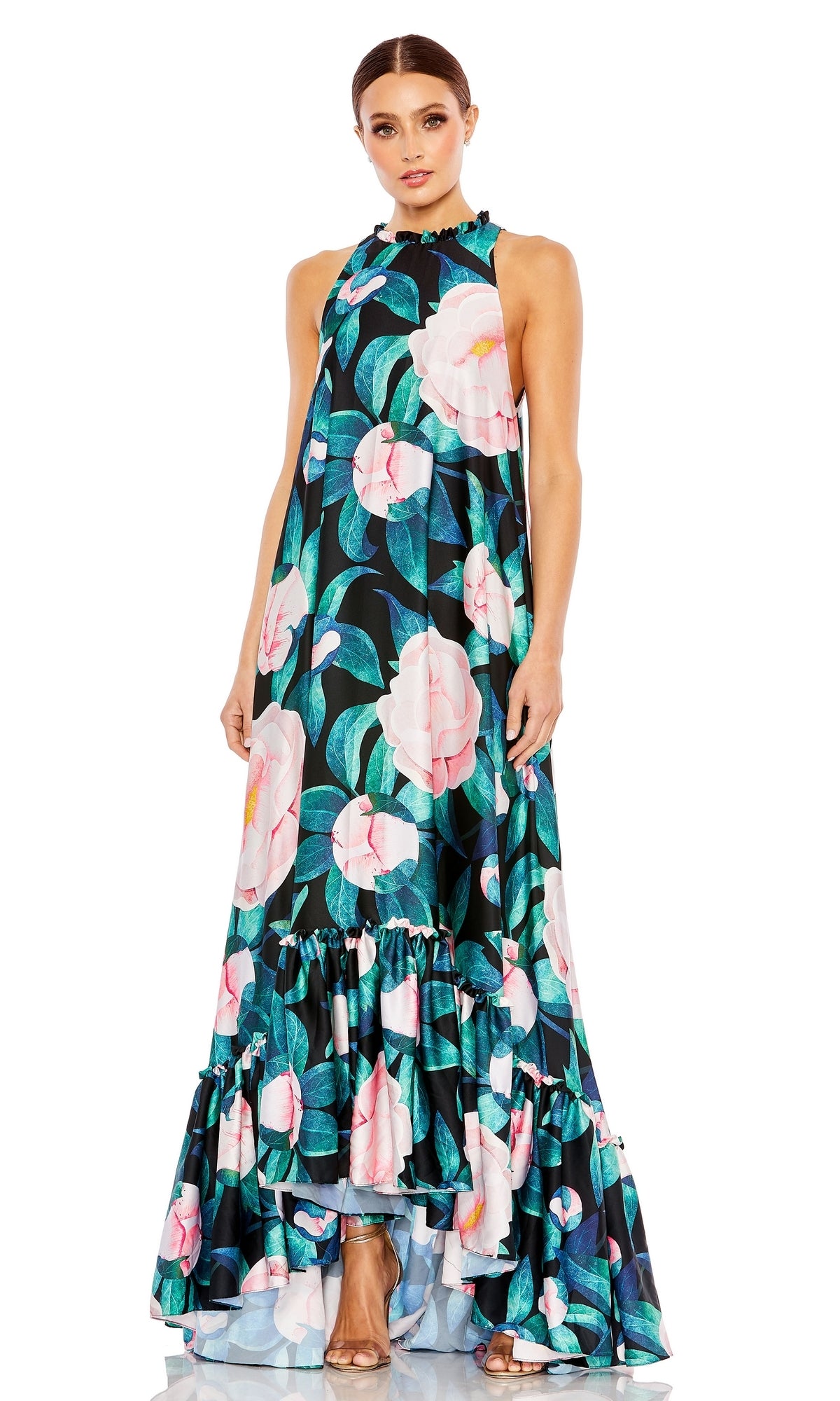 Woman wearing the Mac Duggal 11406 Floral-Print Long Formal Dress, a sleeveless floor-length gown in pink, green, and blue shades with a ruffled hem and high neckline.